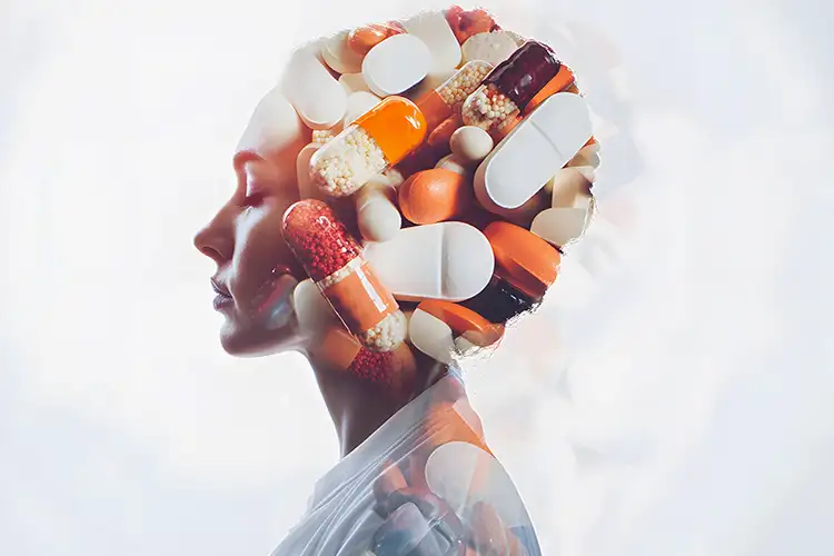 Eine Frau mit vielen Medikamenten im Kopf - symbolisch dafür, wie die Medikamente einen Menschen einnehmen können