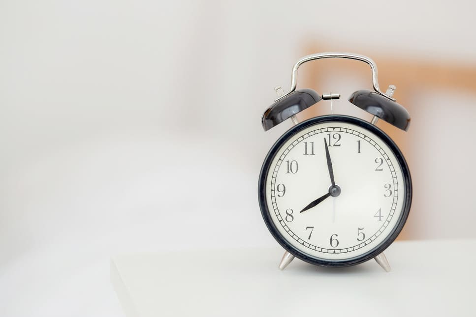 Nahaufnahme eines manuellen Weckers, der auf einem weißen Tisch steht