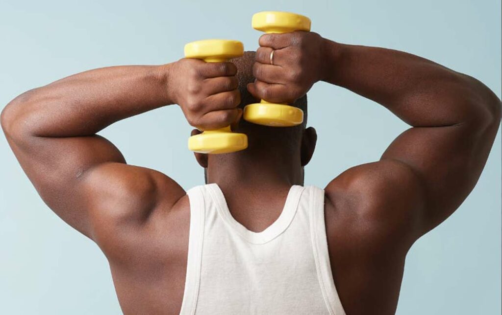Mann trainiert mit Hanteln als Verhalten nach der Haartransplantation