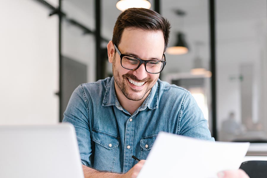 Patient schaut zufrieden auf seine Unterlagen für die Haartransplantation Finanzierung