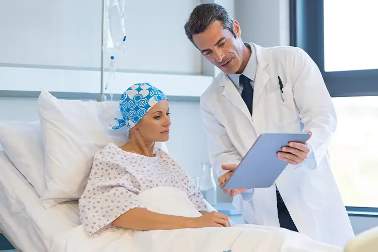 Arzt spricht mit Krebspatientin im Krankenhausbett – symbolisiert medizinische Aufklärung und emotionale Begleitung während der Therapie
