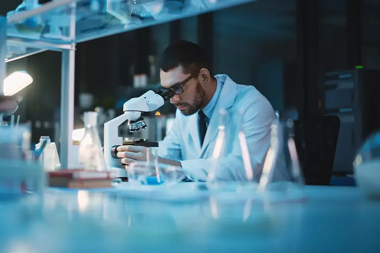 Wissenschaftler analysiert mit dem Mikroskop im Labor