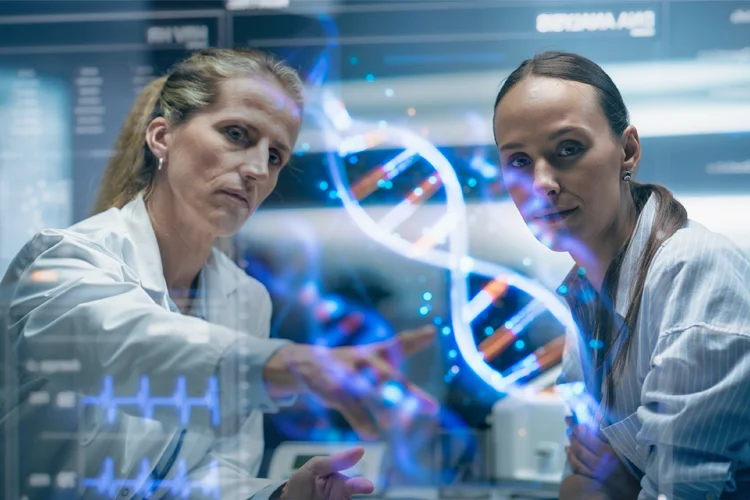 Zwei Frauen im Labor forschen und schauen auf einen Bildschirm, auf dem ein DNA-Strang zu sehen ist.