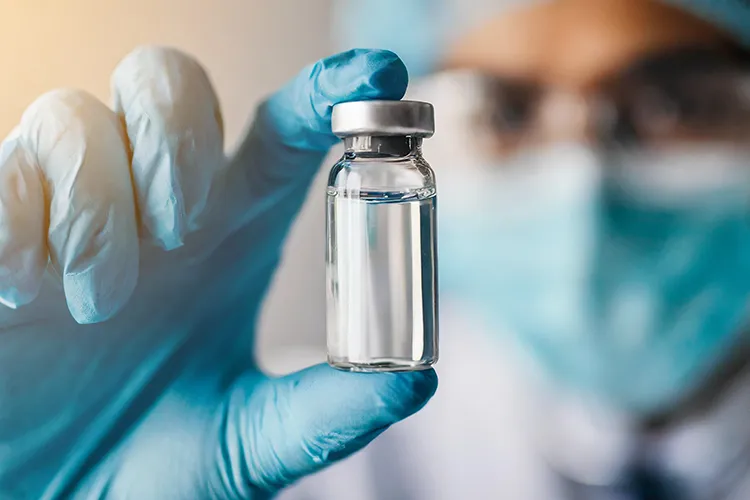 Forscher hält eine Ampulle mit Flüssigkeit im Labor