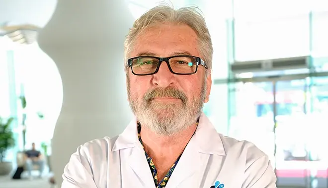 Dr. Erbil Zilan sitzt im Stuhl an einem Tisch in der Elit Klinik