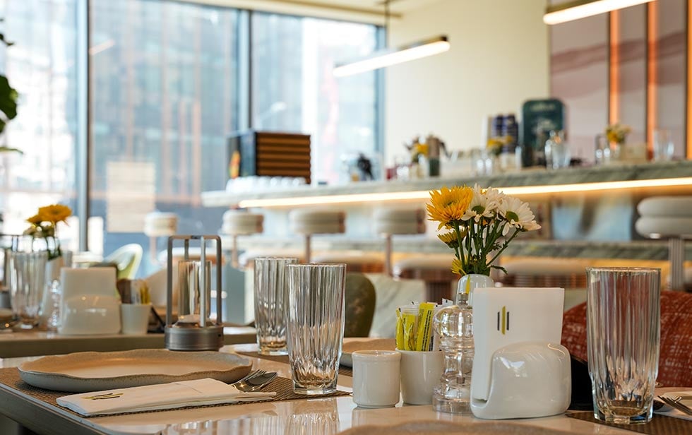 Tischdekoration im Elitoria Hotel mit weißen und gelben Blumen im Vordergrund