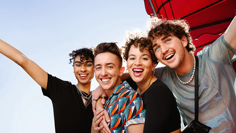 Gruppe junger Menschen lächelt gemeinsam in die Kamera